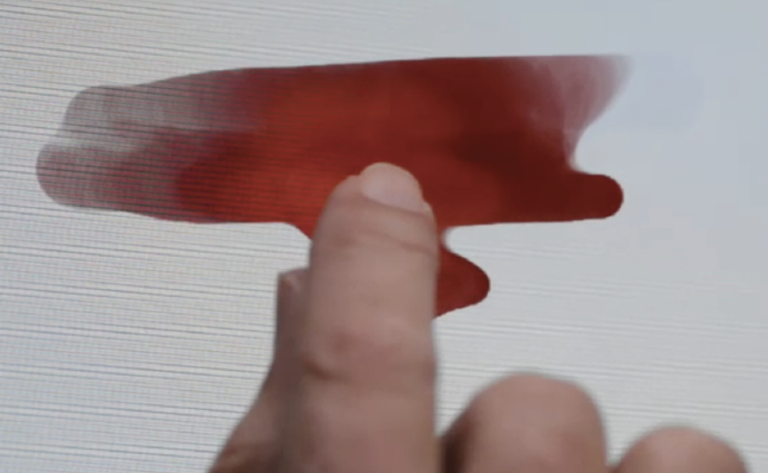 A finger painting a red watercolor stroke in Adobe Eazel on iPad